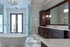 A closer look at the luxury master bathroom for the North Palm Beach project, showcasing rich walnut, traditional doors, and ornate details.